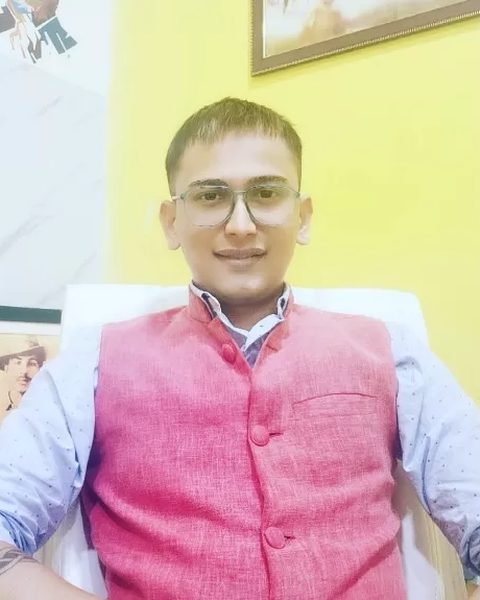Snehaashish Pathakk seated in an office in a pink Nehru jacket and glasses, 2023.
