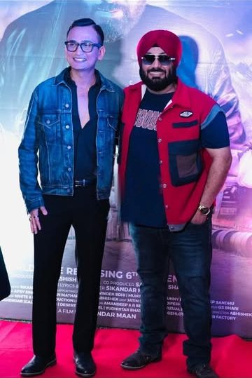 Snehaashish Pathakk in a denim jacket beside Sikandar Maan in front of the ATHRU backdrop, November 2025.